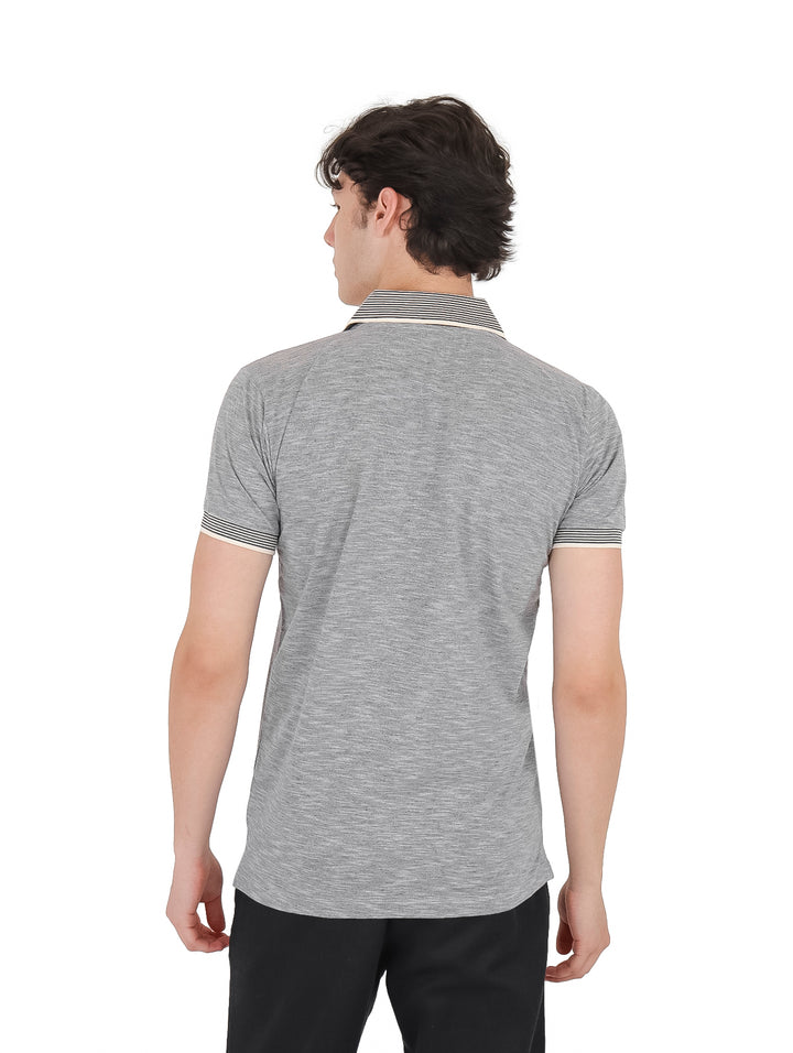 Hombre vistiendo playera polo color gris jaspe con cuello a rayas y cierre frontal.