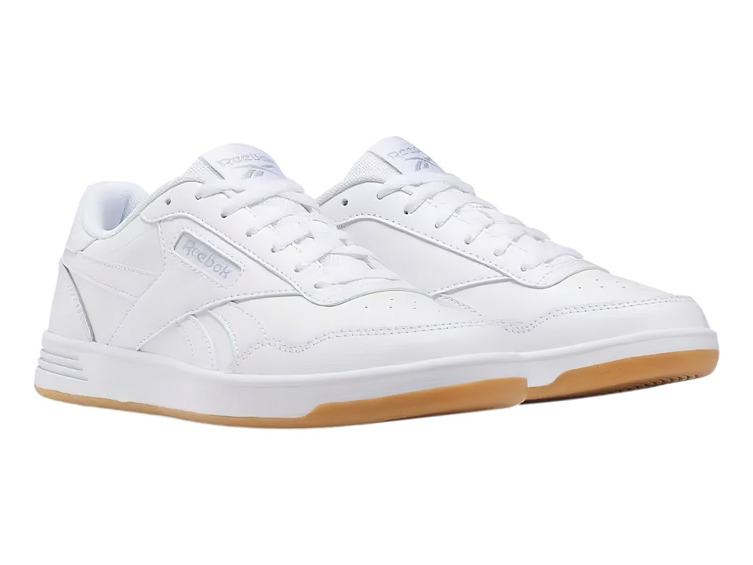 Tenis Reebok Court Advance en color blanco con suela de goma color miel.
