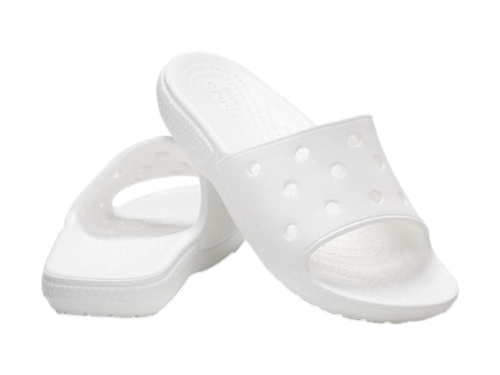 Par de sandalias Crocs Classic Slide V2 en color blanco con perforaciones circulares en la banda superior.