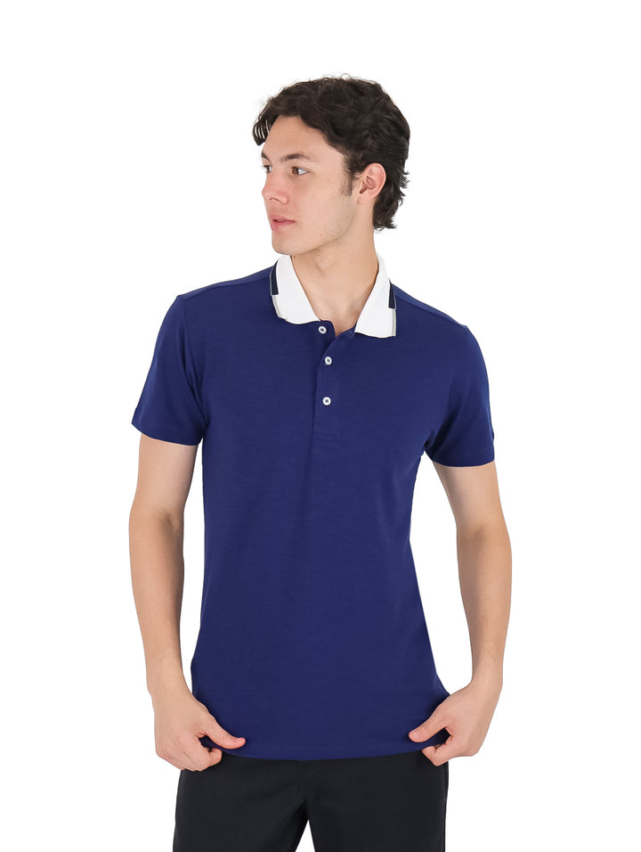 Hombre vistiendo playera polo color azul marino con cuello blanco.