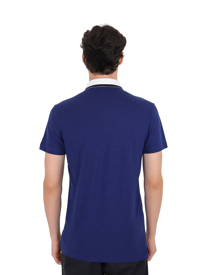 Hombre vistiendo playera polo color azul marino con cuello blanco.