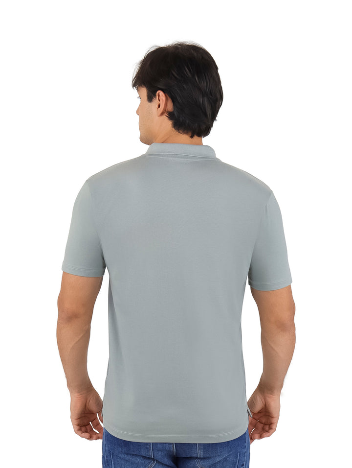 Hombre vistiendo una playera polo color gris de manga corta con cuello y botones.