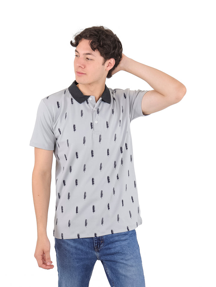 Hombre vistiendo playera polo gris con cuello negro y estampado pequeño repetido en color negro.