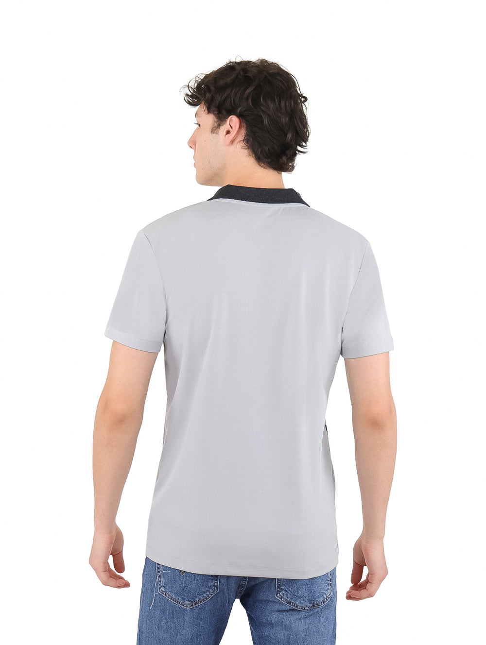 Hombre vistiendo playera polo gris con cuello negro y estampado pequeño repetido en color negro.