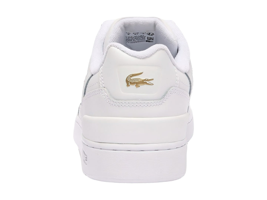 Tenis Lacoste blancos de cuero con logotipo dorado y suela blanca.