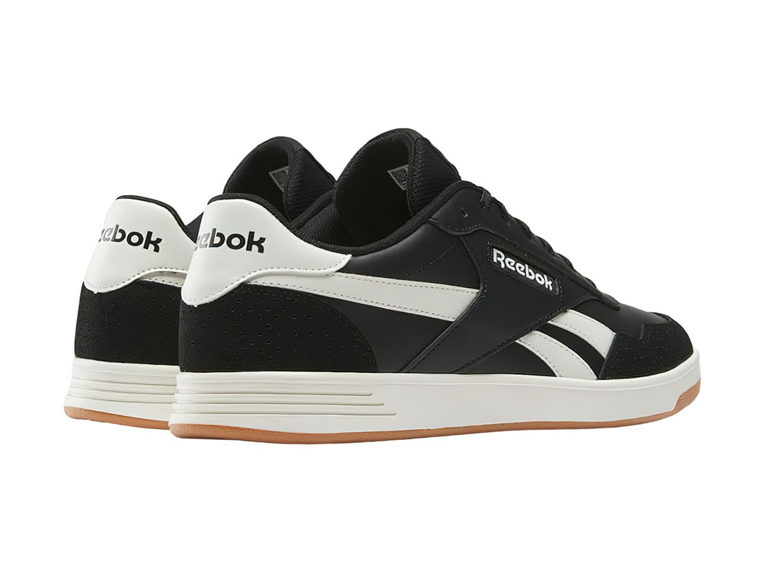 Tenis Reebok Court Advance color negro con detalles en blanco y suela de goma color miel.