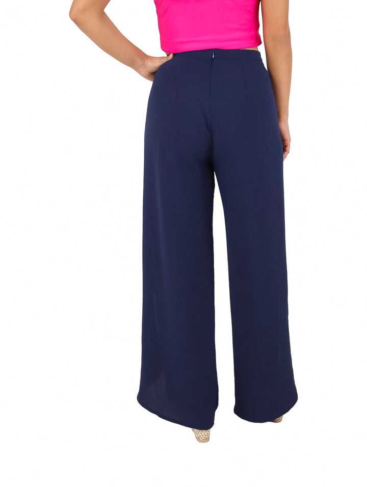 Mujer vistiendo pantalones anchos de color azul marino con aberturas laterales.