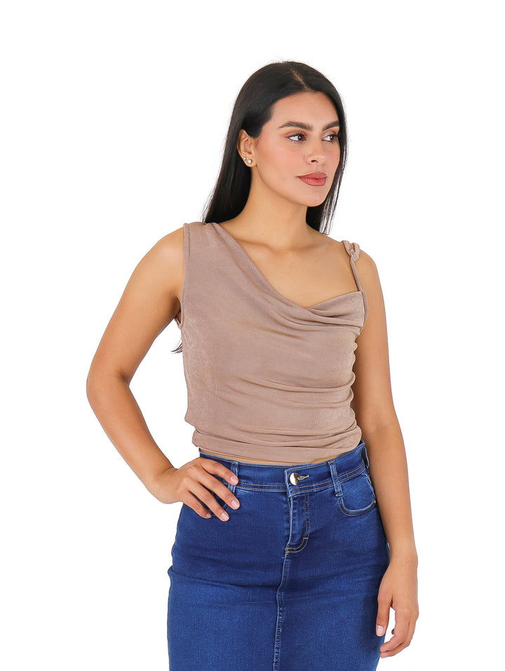 Mujer vistiendo blusa color café con cuello drapeado y falda vaquera azul