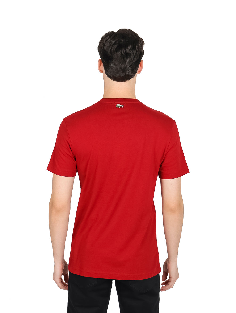 Hombre vistiendo una camiseta roja de manga corta y cuello redondo de la marca Lacoste.