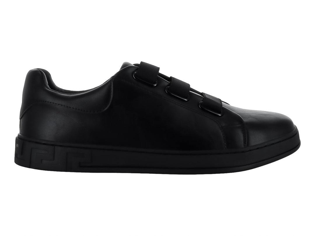 Zapato casual negro para niño con cierre de tres tiras de velcro y suela con relieve lateral.