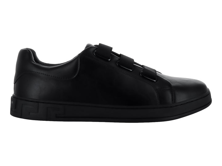 Zapato casual negro para niño con cierre de tres tiras de velcro y suela con relieve lateral.