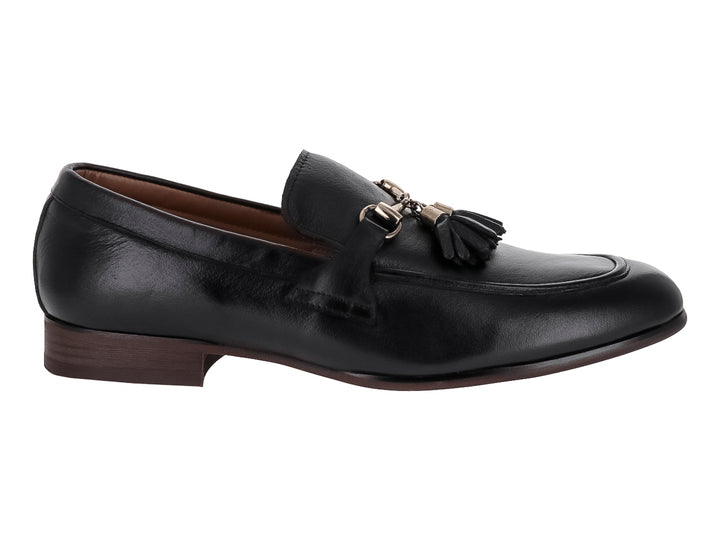 Zapato mocasín de cuero negro con borlas y suela oscura.