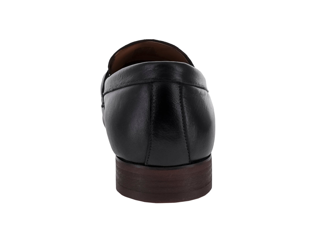 Zapato mocasín de cuero negro con borlas y suela oscura.