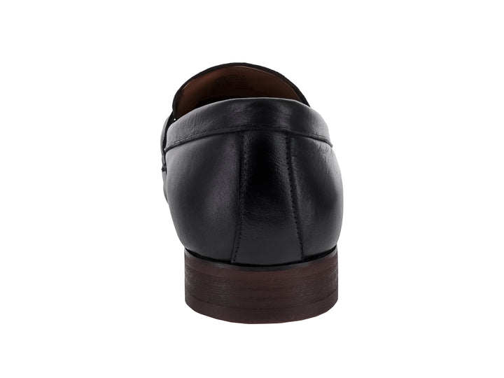Zapato mocasín de cuero negro con borlas y suela oscura.