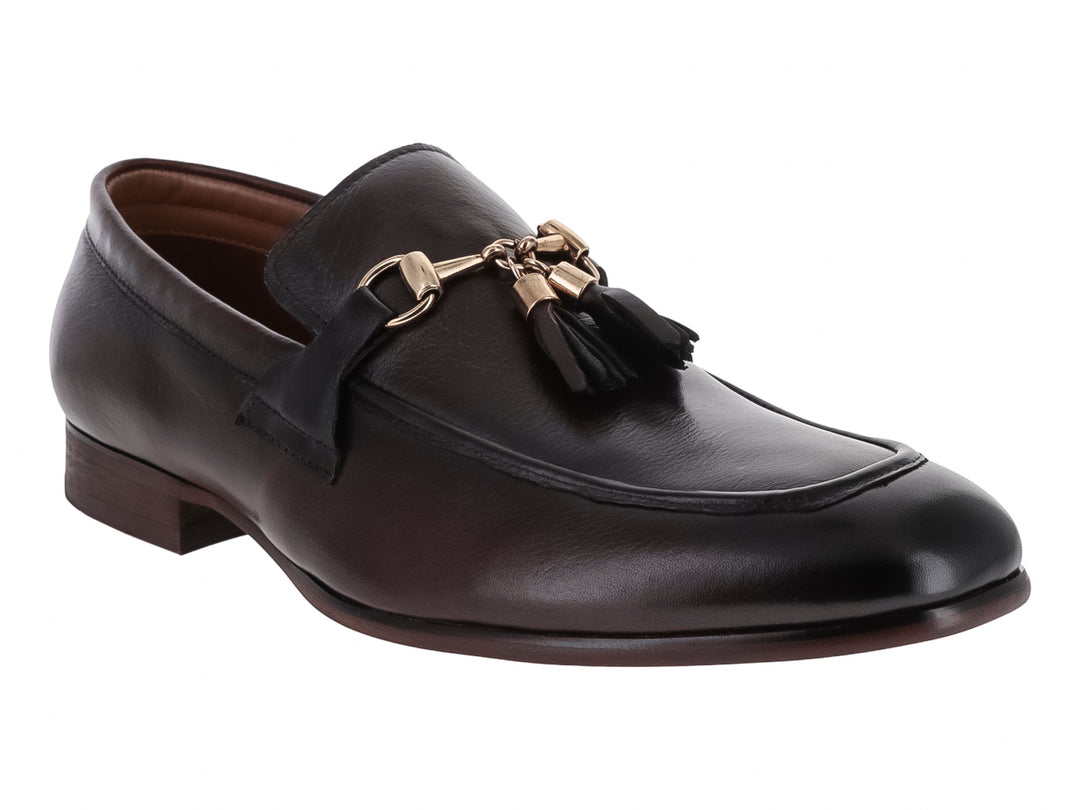 Zapato mocasín de cuero marrón con borlas y detalle metálico dorado.