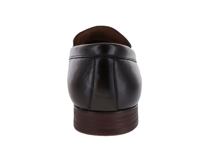 Zapato mocasín de cuero marrón con borlas y detalle metálico dorado.