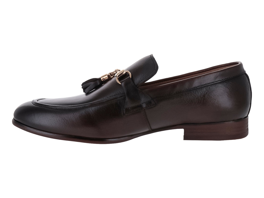 Zapato mocasín de cuero marrón con borlas y detalle metálico dorado.