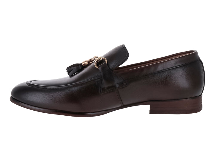 Zapato mocasín de cuero marrón con borlas y detalle metálico dorado.