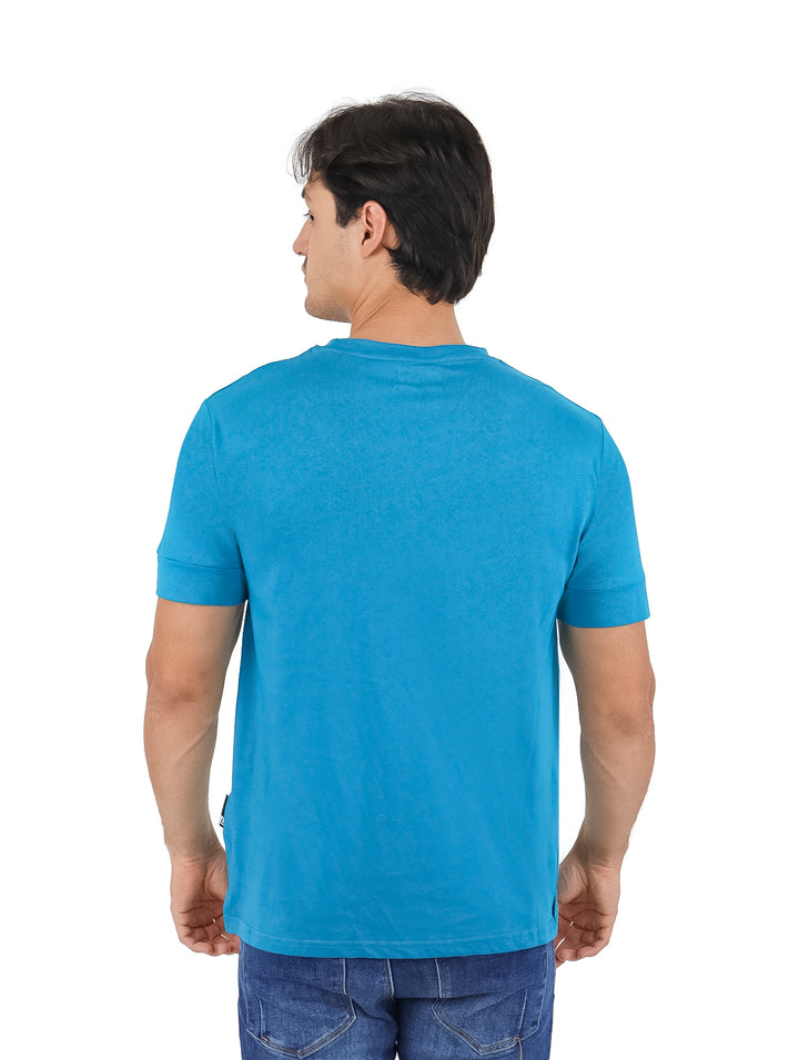 Hombre vistiendo playera azul de manga corta con estampado gráfico frontal.