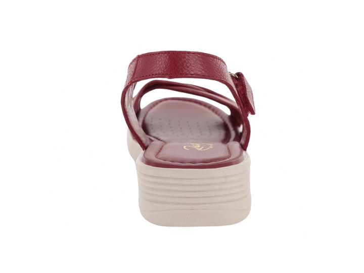 Sandalia color rojo con plataforma beige y correa ajustable en el tobillo.