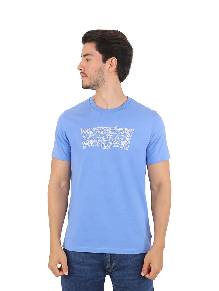 Hombre vistiendo una camiseta de manga corta color azul con estampado gráfico en el pecho.