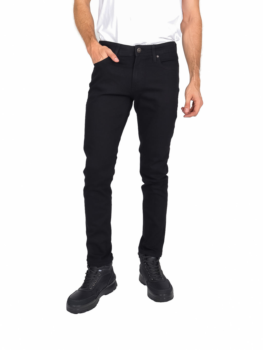 Hombre vistiendo pantalones ajustados de color negro y botas negras sobre fondo blanco.