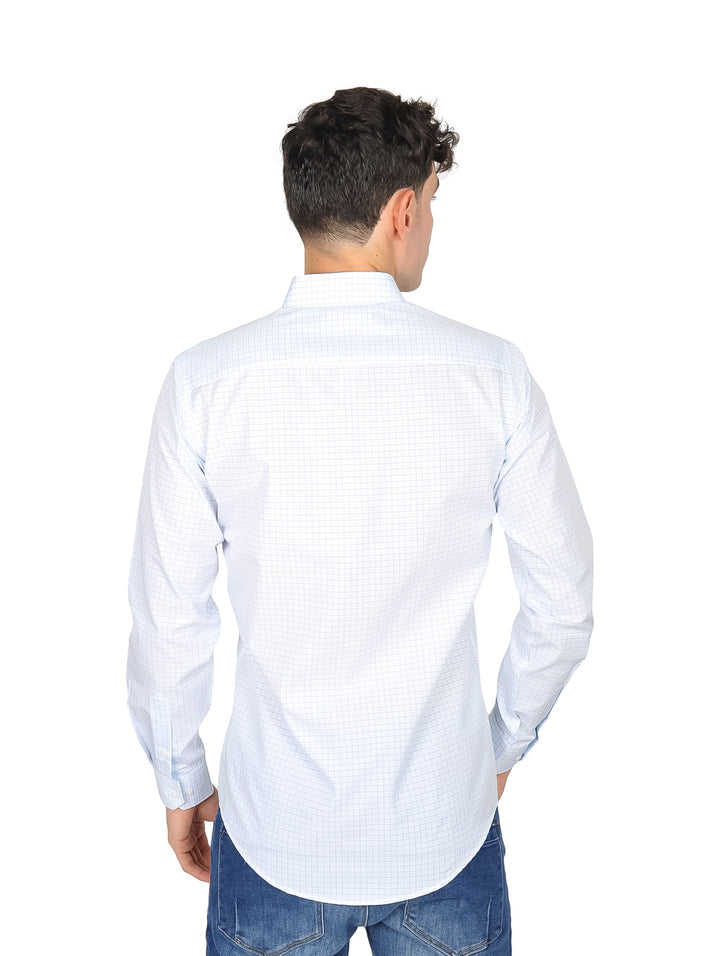 Hombre vistiendo una camisa de manga larga color menta con patrón de cuadros pequeños y jeans azules.