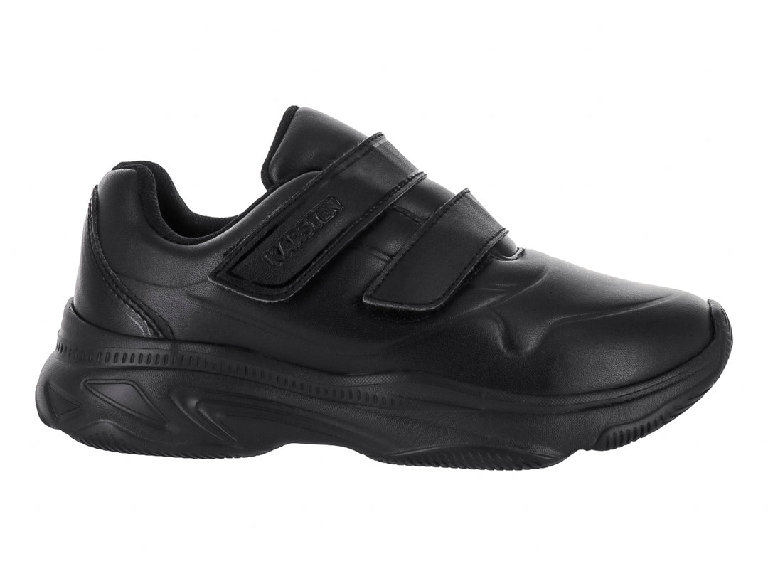 Zapato deportivo negro para niño con cierre de velcro y suela robusta sobre fondo blanco.