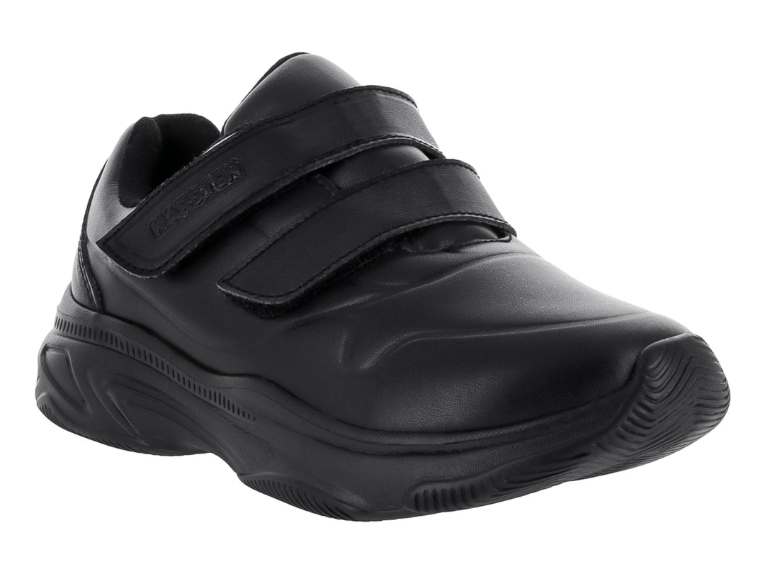 Zapato deportivo negro para niño con cierre de velcro y suela robusta sobre fondo blanco.