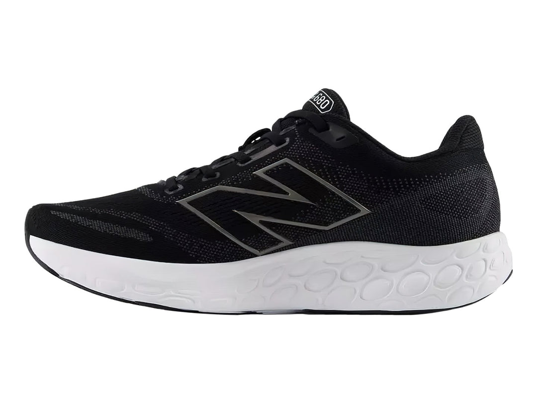 Tenis deportivos New Balance color negro con suela blanca y detalles en gris.