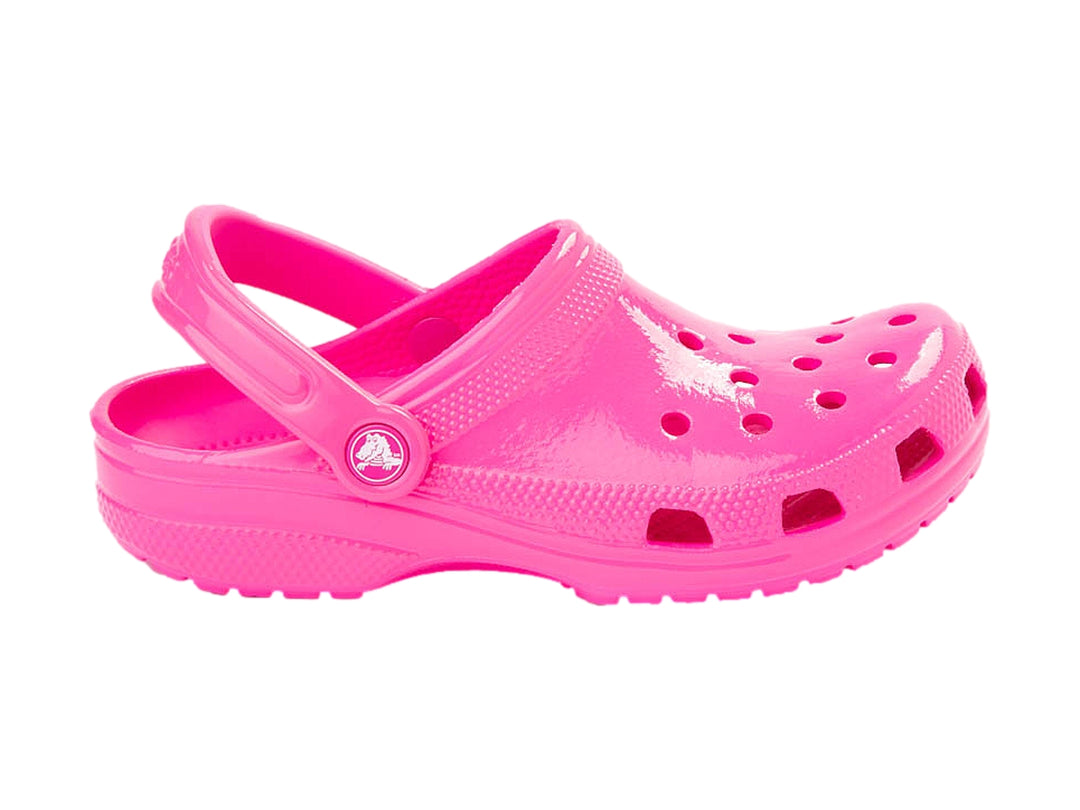 Zueco Crocs color rosa neón brillante con correa ajustable y orificios de ventilación.