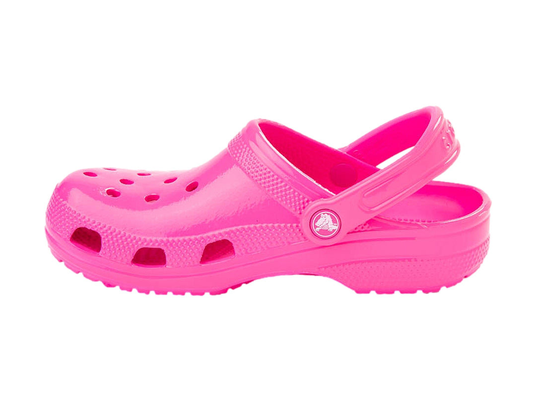 Zueco Crocs color rosa neón brillante con correa ajustable y orificios de ventilación.