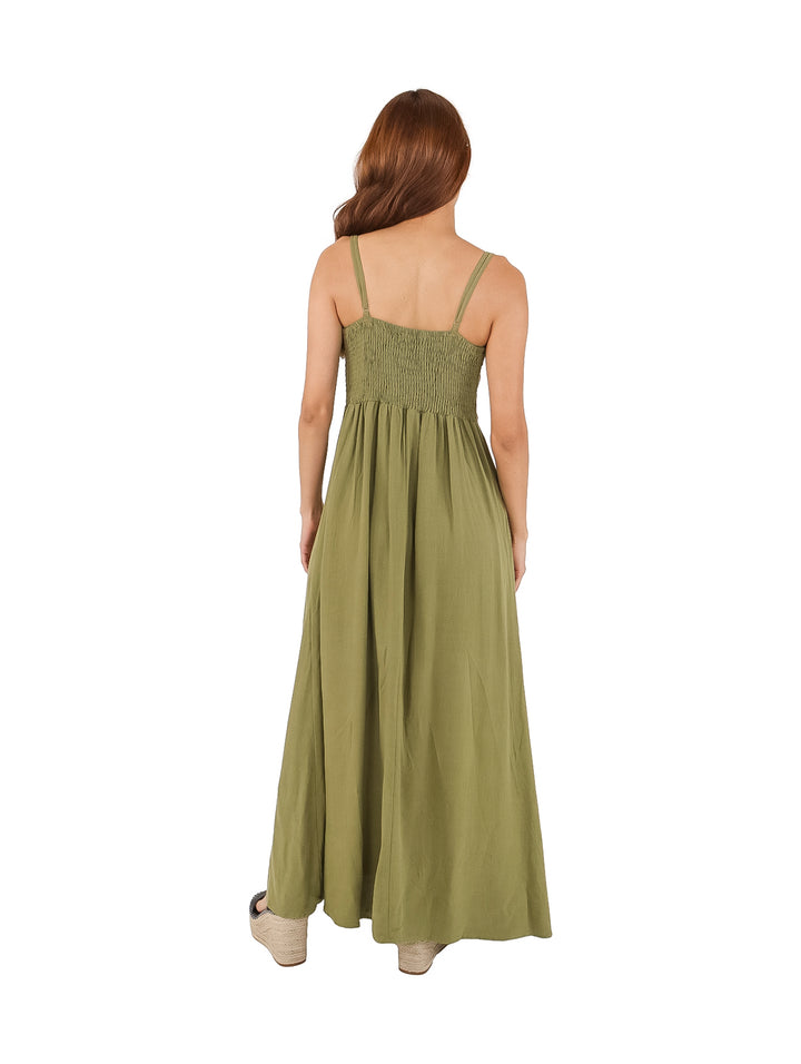 Mujer vistiendo un vestido largo de color verde con tirantes y detalle de lazo en el pecho.