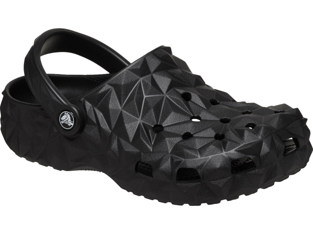 Zueco Crocs negro con relieve geométrico facetado y correa trasera ajustable.