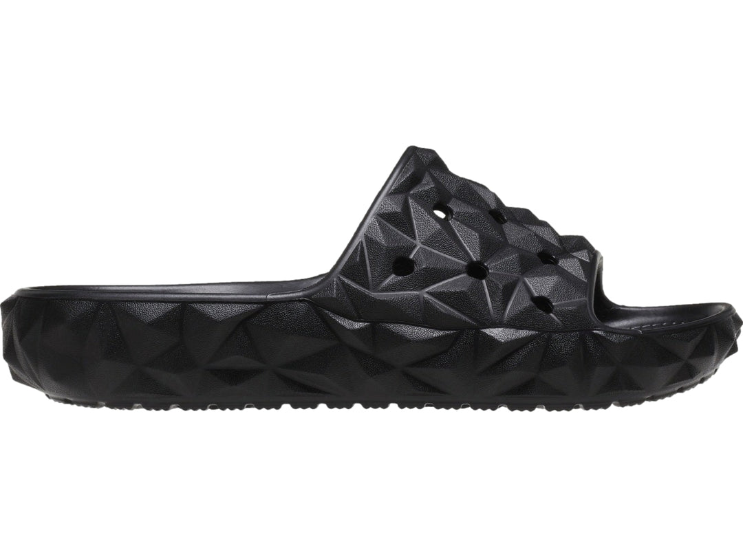 Sandalia Crocs Classic Geometric Slide en color negro con diseño de relieve geométrico tridimensional.