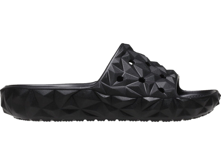 Sandalia Crocs Classic Geometric Slide en color negro con diseño de relieve geométrico tridimensional.