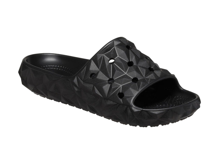 Sandalia Crocs Classic Geometric Slide en color negro con diseño de relieve geométrico tridimensional.