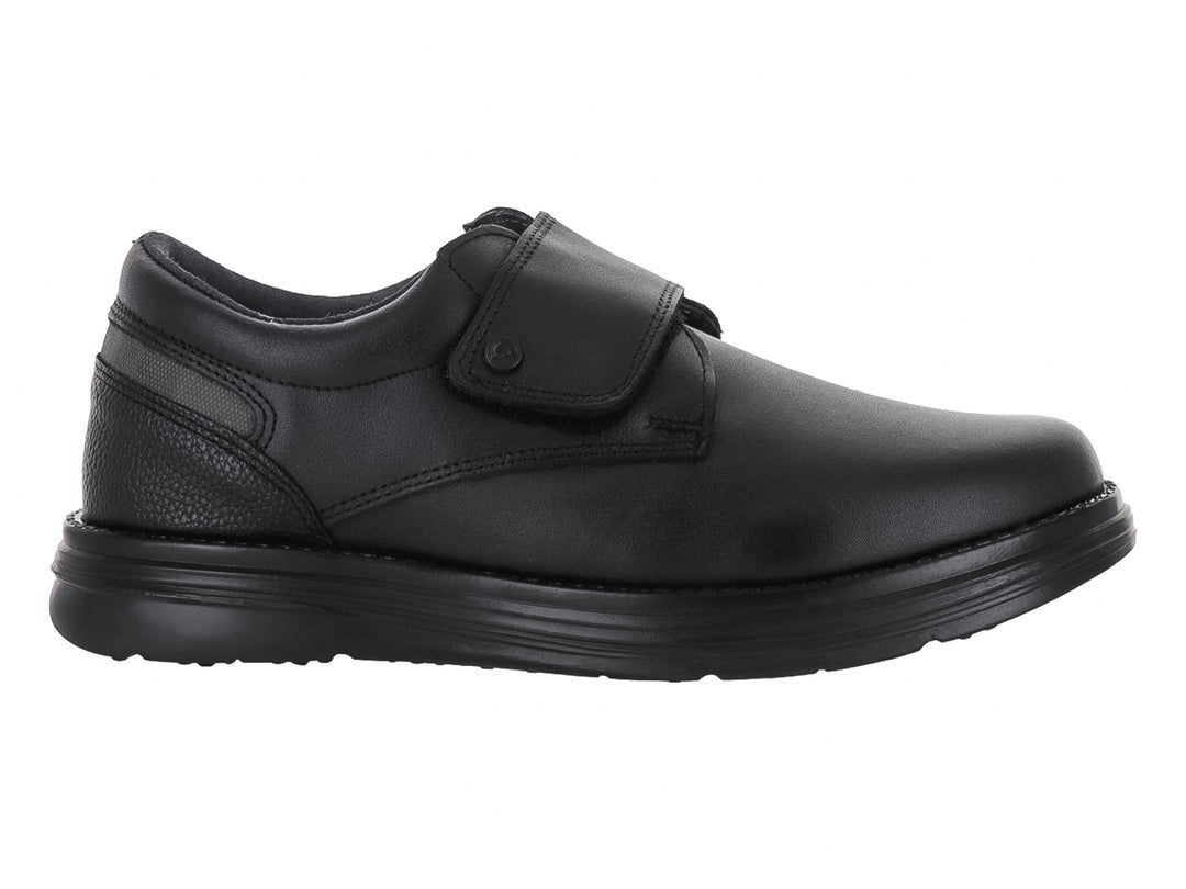 Zapato escolar negro para niño con cierre de velcro y suela negra.