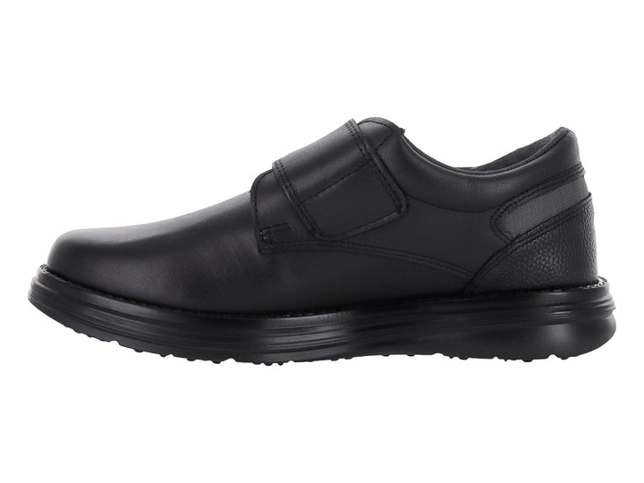 Zapato escolar negro para niño con cierre de velcro y suela negra.
