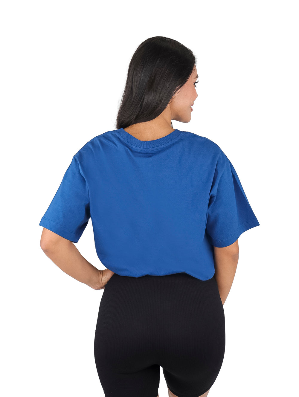 Mujer vistiendo camiseta azul de manga corta DKNY Sport con ajuste en la cintura.