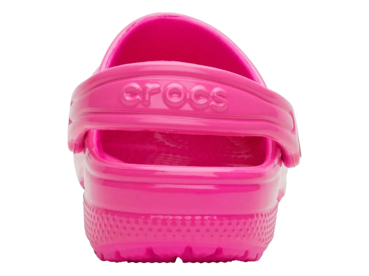 Zuecos Crocs Classic en color rosa neón brillante con correa ajustable trasera.