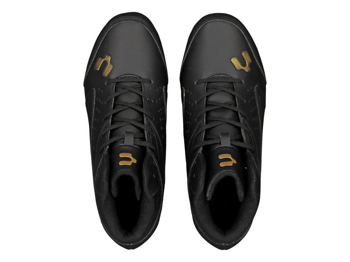 Zapato deportivo tipo botín de color negro con suela de tacos dorados.