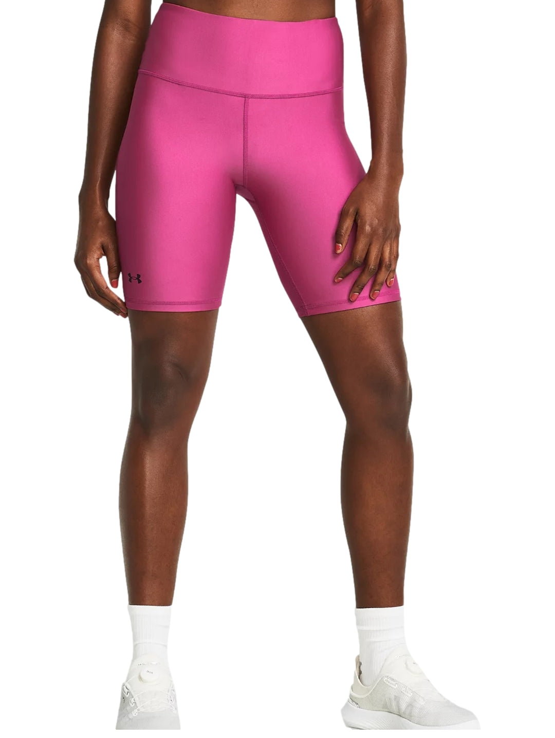 Mujer vistiendo shorts deportivos ajustados de color rosa intenso de la marca Under Armour.