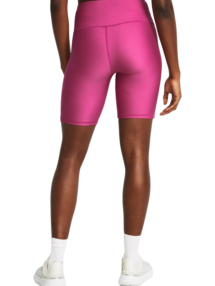 Mujer vistiendo shorts deportivos ajustados de color rosa intenso de la marca Under Armour.