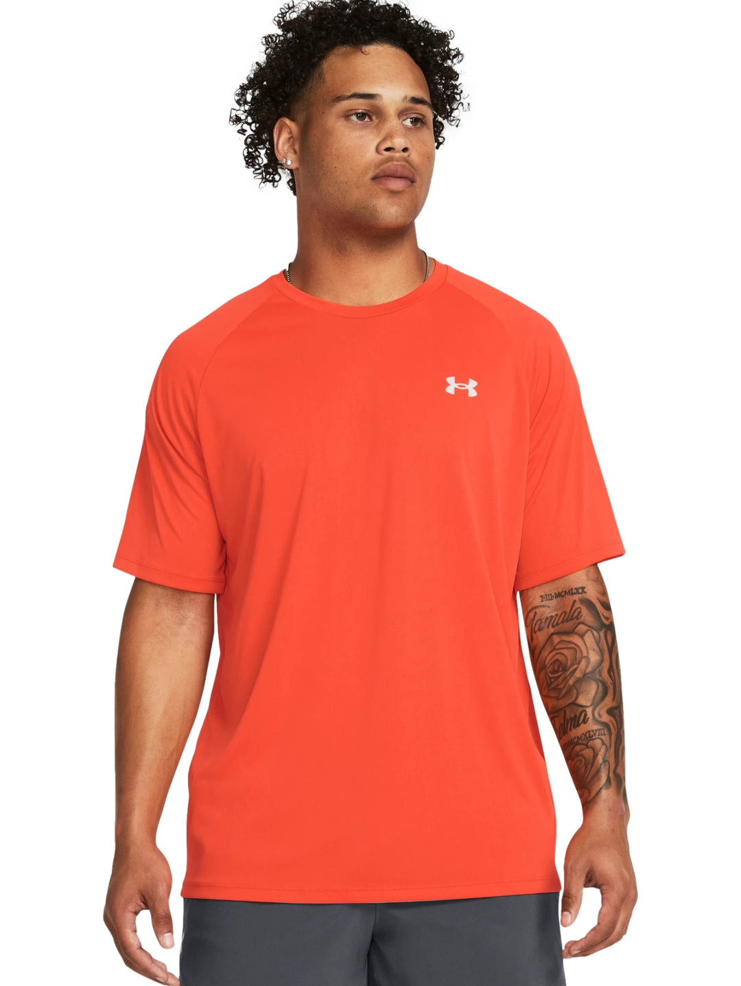 Hombre vistiendo una camiseta deportiva de manga corta color naranja con logotipo blanco en el pecho.