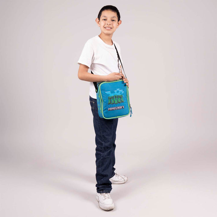 Lonchera infantil azul y verde de Minecraft con diseño de creepers, asa negra y cierre doble.
