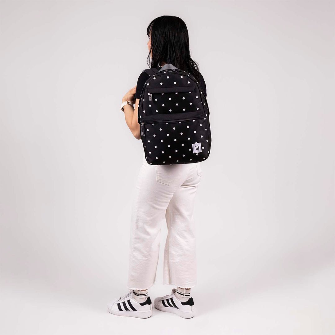 Mochila juvenil de color negro con estampado de puntos blancos, marca Chenson, con múltiples compartimentos.