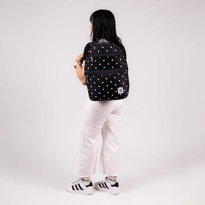 Mochila juvenil de color negro con estampado de puntos blancos, marca Chenson, con múltiples compartimentos.
