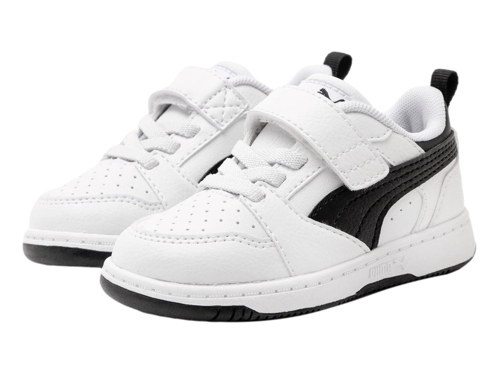 Tenis PUMA blancos con detalles negros, cierre de velcro y cordones para niño o niña.