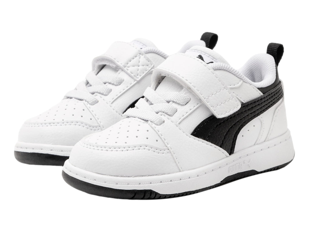 Tenis PUMA blancos con detalles negros, cierre de velcro y cordones para niño o niña.
